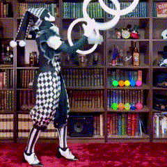 a clown is juggling rings in front of a bookcase
