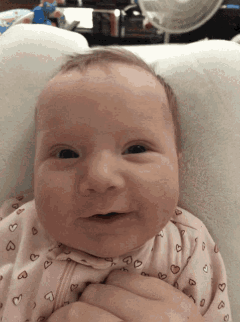 a baby in a pink pajamas with hearts on it