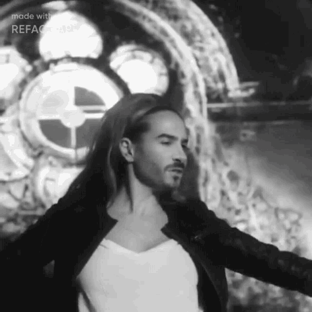 a black and white photo of a man with long hair and a beard