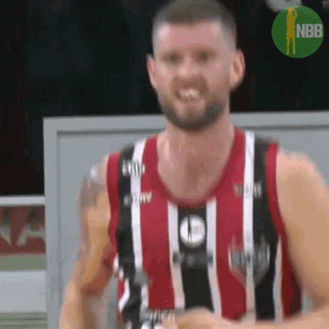 a basketball player wearing a red and black jersey with the nbb logo on the bottom