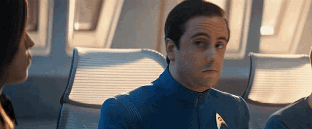 a man in a blue uniform has a star trek badge