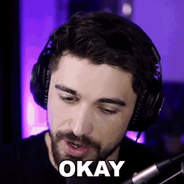 a man wearing headphones and a microphone has the word okay written on his face