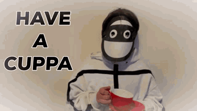 a person wearing a mask is holding a cup and saucer with the words have a cuppa written above them