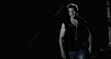 a man is walking down the street at night