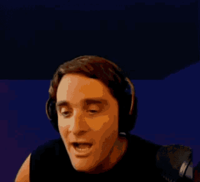 a man wearing headphones is talking into a microphone .