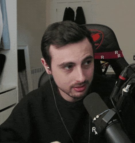 a man wearing headphones and a microphone with the letter r on the front
