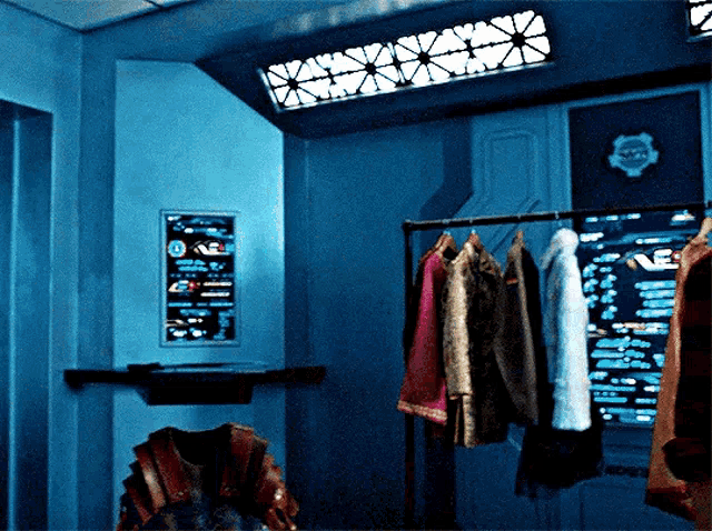 a blue room with clothes hanging on a rack and a sign on the wall that says ' a '