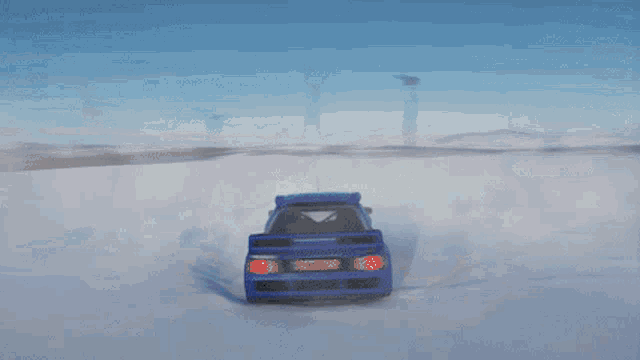 a blue car is driving through a snow covered field