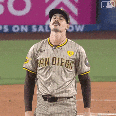a man in a san diego baseball uniform stands on the field