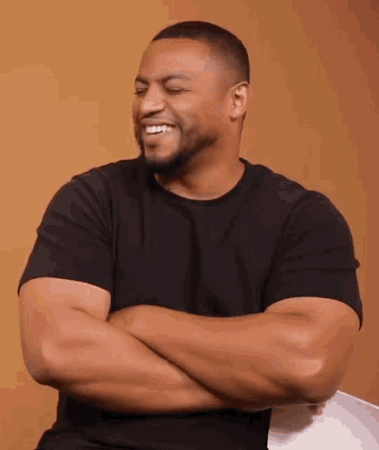 a man with his arms crossed is smiling