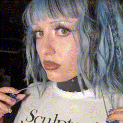 a woman with blue hair is wearing a white t-shirt that says sculpt