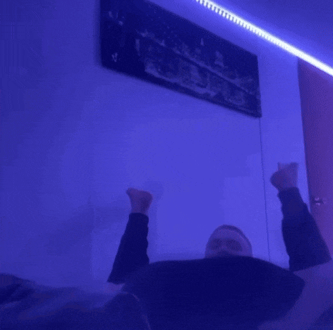 a man in a black shirt is sitting in a dark room