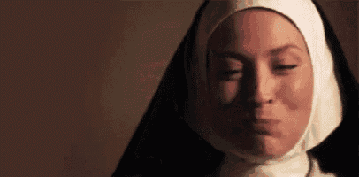 a close up of a nun with her eyes closed and a black veil .