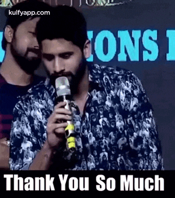 a man with a beard is holding a microphone in his mouth and talking into it .