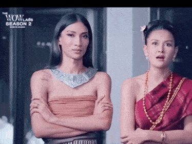 two women are standing next to each other in front of a sign that says " the wow laos season 2 "