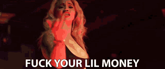 a woman singing into a microphone with the words " fuck your lil money " behind her