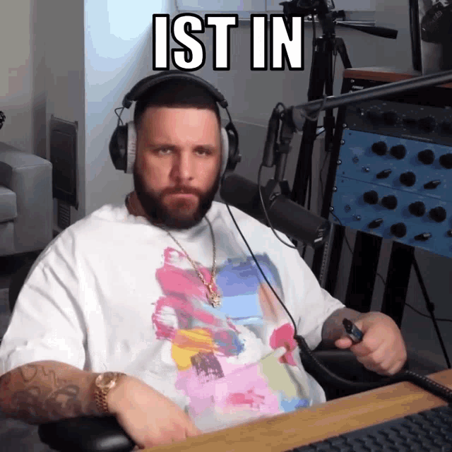 a man wearing headphones sitting at a desk with the word ist in above him