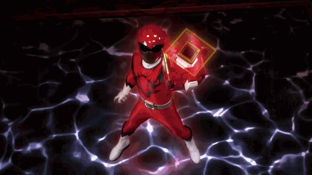 a man in a red power ranger costume stands in front of a glowing cube