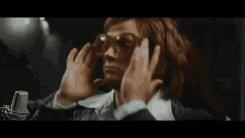 a man with red hair is wearing a pair of sunglasses .