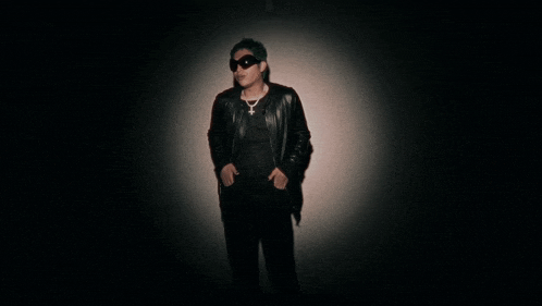 a man with green hair is wearing sunglasses and a black leather jacket