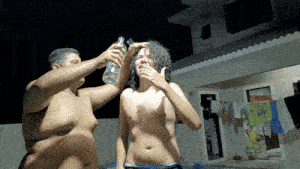 a shirtless man drinks from a bottle next to another man