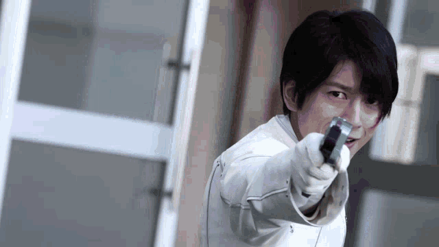 a man in a white jacket is pointing a blue object