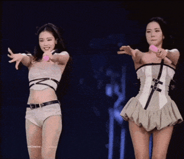 two women are standing next to each other on a stage .