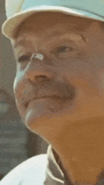 a close up of a man with his mouth open wearing a hat