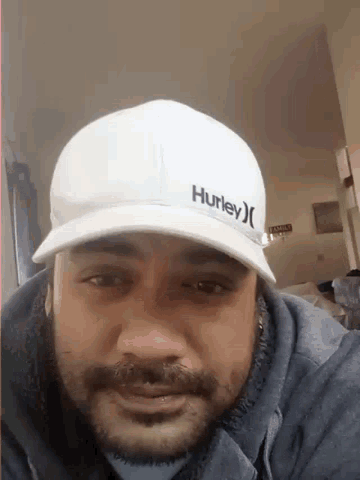 a man wearing a hurley hat is smiling and looking at the camera