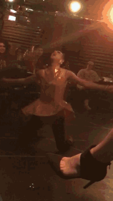 a woman in a latex dress is dancing in a dark room