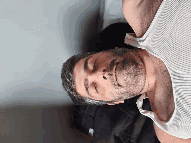 a man with a beard wearing a tank top