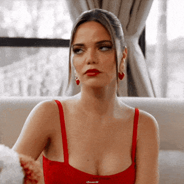 a woman in a red dress is sitting on a chair