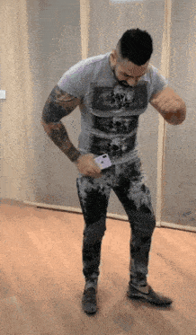 a man wearing a grey shirt with a skull on it