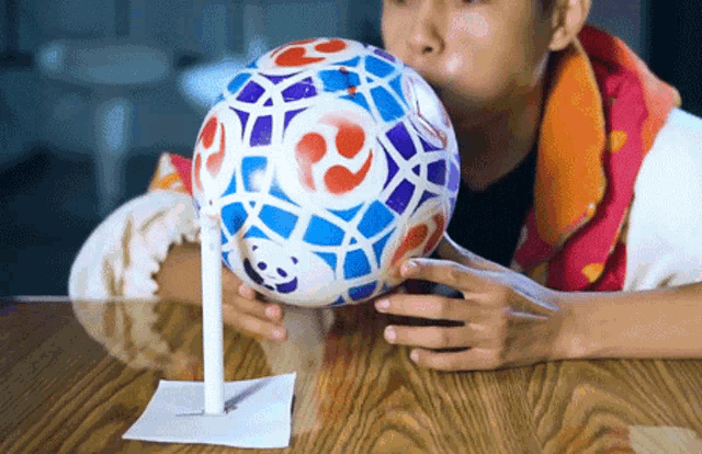 a person is blowing up a colorful ball with a panda on it