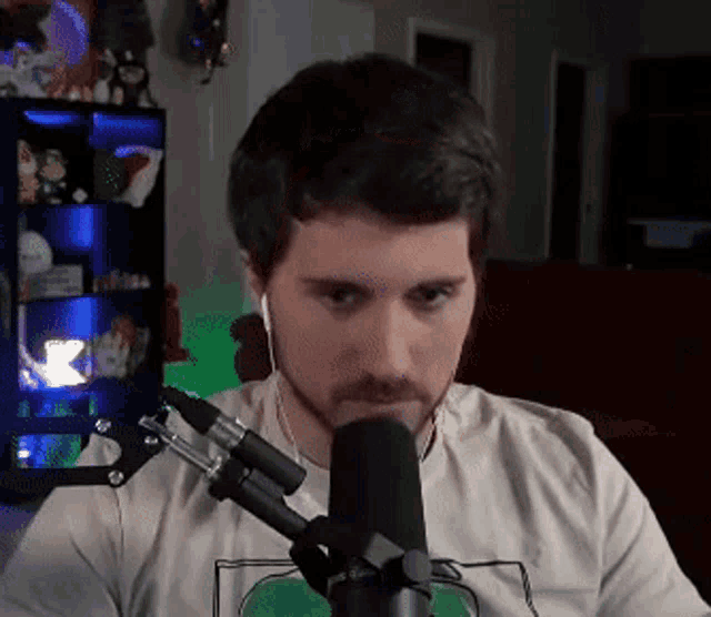 a man with a beard is wearing ear buds and a microphone