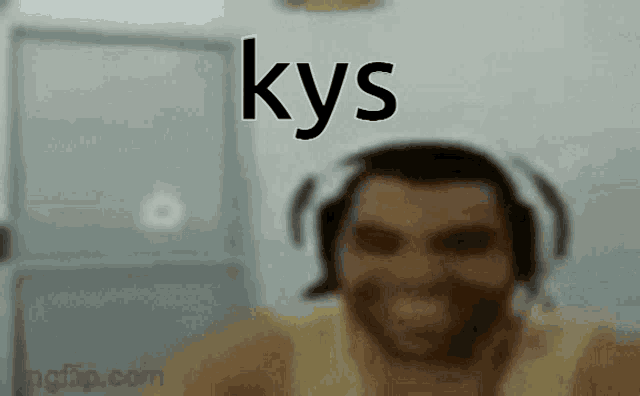 a man wearing headphones is smiling in a blurry photo with the word kys written above him .