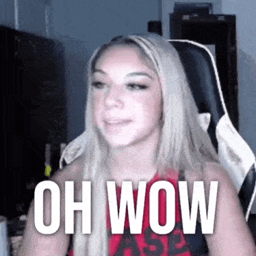 a woman is sitting in a chair with the words oh wow written on her chest .