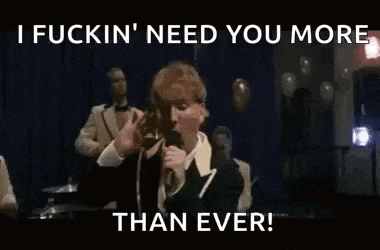 a man in a suit is singing into a microphone .
