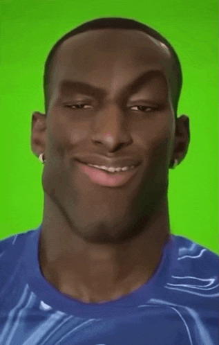 a man in a blue shirt is smiling and making a funny face