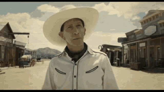 a man in a cowboy hat is standing in front of a building that says ' abercrombie ' on it