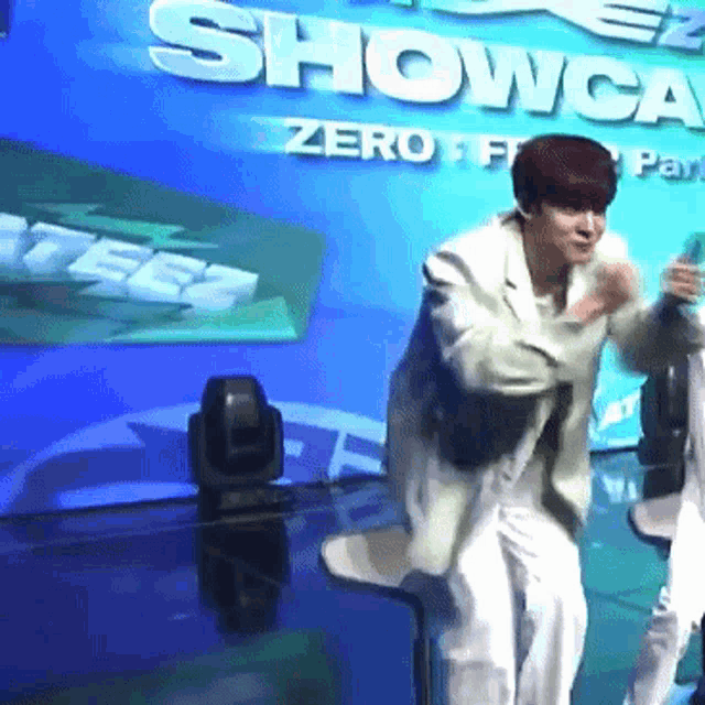 a man is dancing in front of a sign that says showcasing