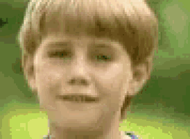 a close up of a young boy 's face with a blurred background .