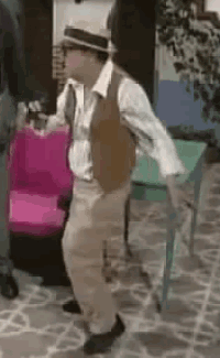 a man wearing a hat and vest is dancing on a stone floor .