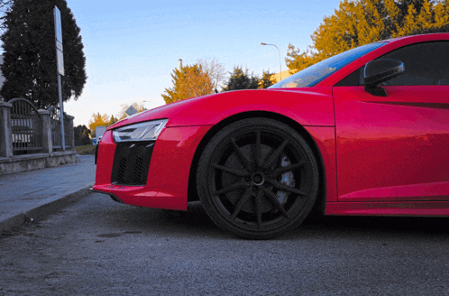 a red sports car is parked on the side of a road
