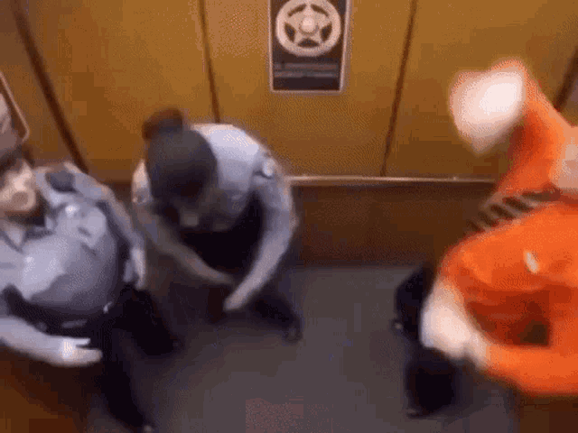 a group of people are standing in an elevator with a sign on the wall that says sheriff 's office .
