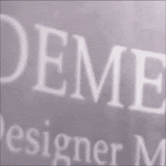 a man with a beard is standing in front of a sign that says oem designer .