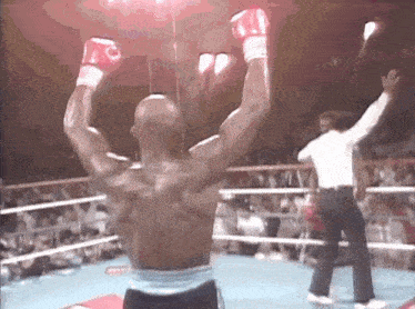 a man in a boxing ring with his arms raised in the air
