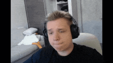 a man wearing headphones is sitting in front of a white couch