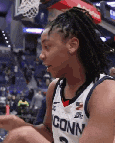 a female basketball player wearing a jersey that says iconn on it