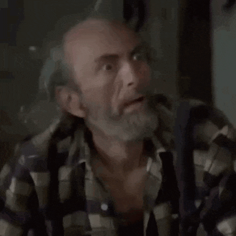 a man with a beard is wearing a plaid shirt and suspenders and making a surprised face .